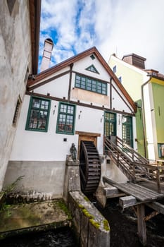 View of white music bar building with big watermill in Cesky Krumlov
