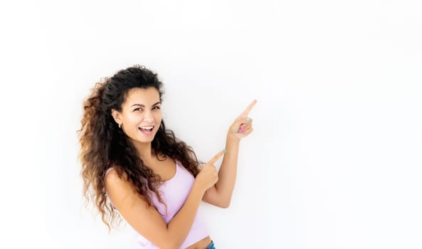 Cheerful young girl standing sideways and pointing up