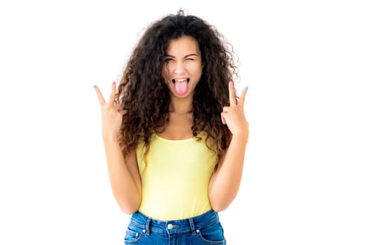 Happy girl with tongue out and blinked eye showing victory gestures