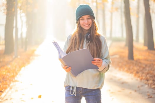 Cute teenage girl reading notes in park