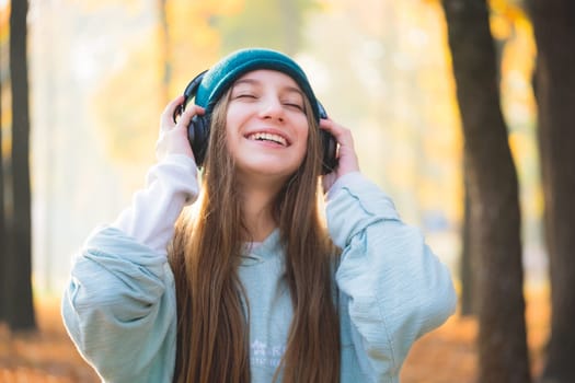 Smiling teenage girl in headphones outdoors