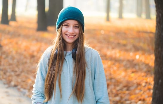 Smiling girl with headphones in nature