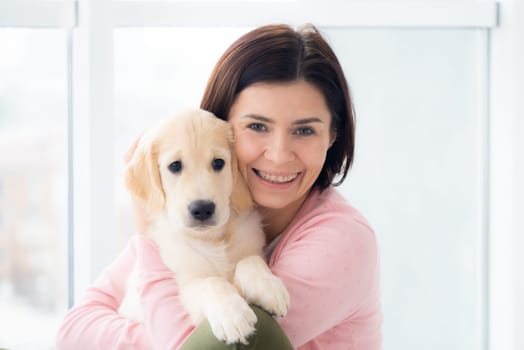 Happy woman cuddling golden retriever dog