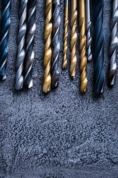 Different sizes drill bits on grey background with copy space