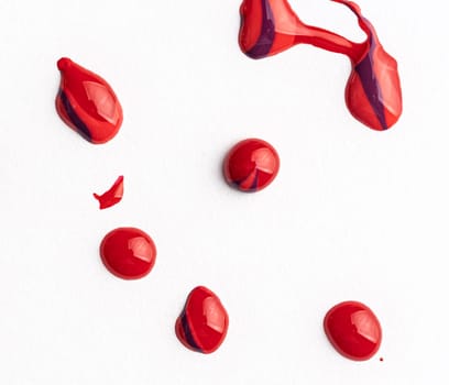 Shiny drops of red enamel isolated on white