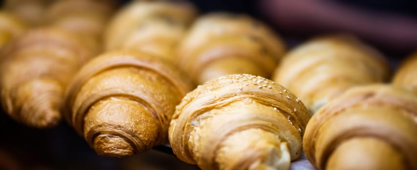 Close up view of tasty croissants sprinkled with sesame