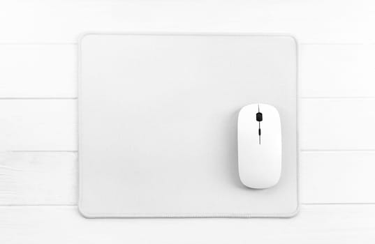 Computer mouse on white mouse pad, top view