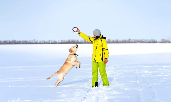 Playful dog with happy owner in winter nature
