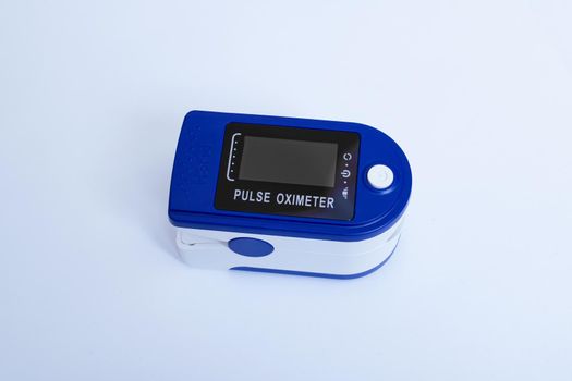One pulse oximeter on a blue background close up