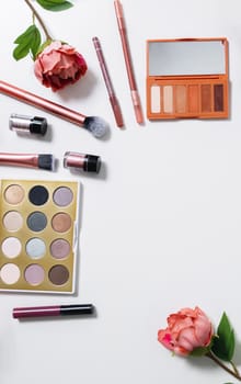 Decorative flat lay composition with cosmetics and flowers. Flat lay, top view on white background