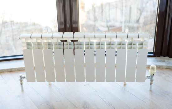 White big radiator near window in a modern room