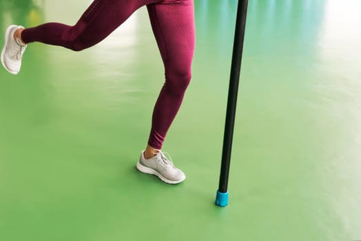 Legs of Young fit woman doing exercise with bodybar in a gym
