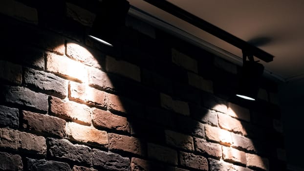Two bright lamps on a red brick wall indoor close up