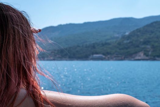 a young woman looks at the shore from a ship. High quality photo