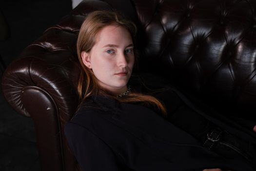 portrait of confident woman in black in dark room. pensive serious people. business woman. feminine. millennial people.