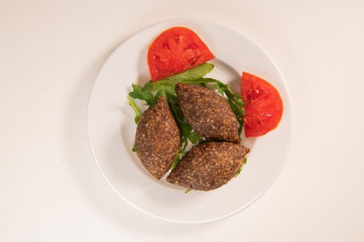 Traditional kebbe and pita bread on big round plate in lebanese restaurant. High quality photo