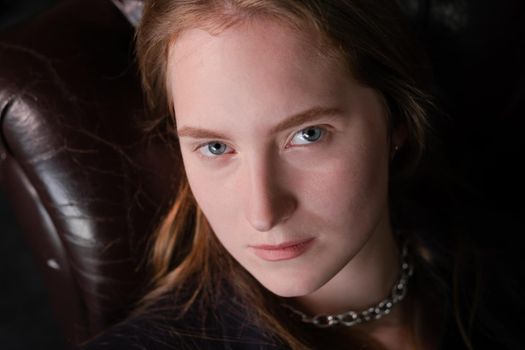 portrait of confident woman in black in dark room. pensive serious people. business woman. feminine. millennial people.