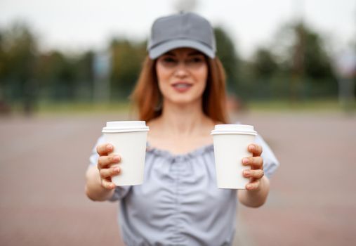 Two white paper cup with coffee in woman hand. Time for drink coffee in city. Coffee to go. Enjoy moment, take a break. Disposable paper cup closeup. Delicious hot beverage. Blank space for text,