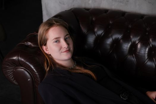 portrait of confident serious brunette woman in black clothes on dark background. femininity.