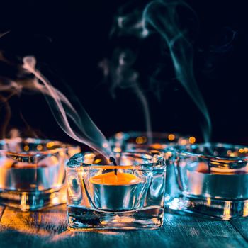 Halloween holiday concept design of pumpkin, candle, spooky decorations with green tone smoke around on a dark wooden table, close up shot.