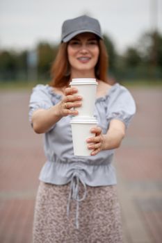 Two white paper cup with coffee in woman hand. Time for drink coffee in city. Coffee to go. Enjoy moment, take a break. Disposable paper cup closeup. Delicious hot beverage. Blank space for text,