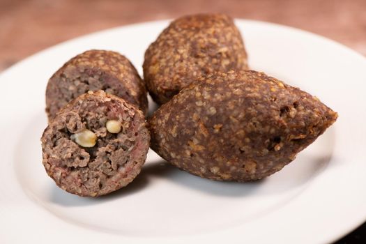 Traditional kebbe and pita bread on big round plate in lebanese restaurant. High quality photo