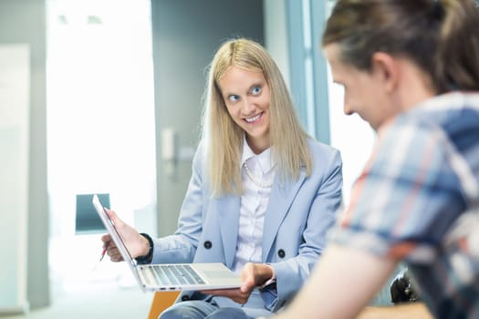 Business meeting. Client consulting. Confident business woman, real estate agent, financial advisor explaining details of project or financial product to client in office