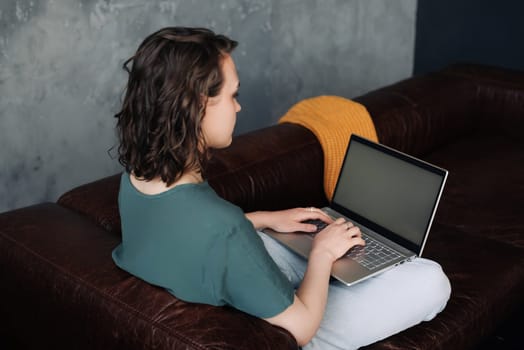 Young Woman Working Remotely on Laptop, Showcasing Blank Screen Mock-up. Depicting Freelancing, Student Lifestyle, E-Learning, Web Conferencing, Video Calls, Technology and Online Shopping Experience.