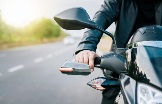 Close up of hands of biker on the handlebars of a motorcycle outdoors. Hands of a motorcyclist on the handlebars on the road. Motorbike speeding concept