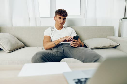 man interior smart mobile sofa internet sitting blogger message selfies curly online adult mockup smile laptop couch blissful phone cyberspace sports