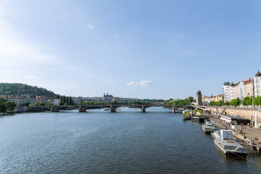 22 May 2022 Prague, Czech Republic. People often gather on embankment to watch ships passing by on Vltava River. Embankment is popular spot for locals and tourists to gather and socialize.