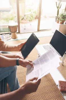 Technology greatly assists them in the budgeting process. Closeup shot of an unrecognisable couple using a digital tablet while going through paperwork together at home