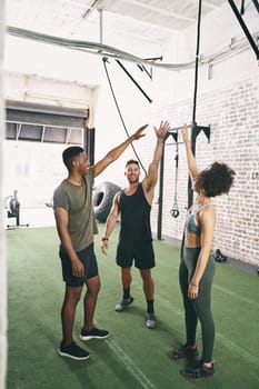 Surround yourself with people who encourage you to do better. three sporty young people looking cheerful at the gym