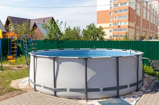 Round large swimming pool in the courtyard of the house for swimming in the summer. Recreation and relaxation for the family.