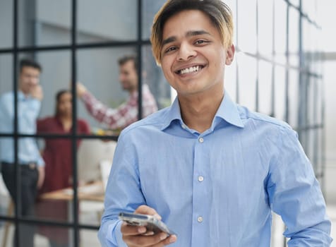confident man uses smartphone in modern office