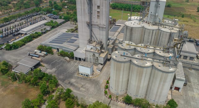 Aerial view of animal feed factory. Agricultural silos, grain storage silos, and solar panel on roofs of industrial plants. Industrial landscape. Agriculture industry. Factory with sustainable energy.