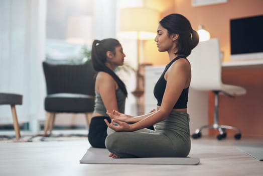 Friends, meditation and women exercise together in a house with mindfulness, health and wellness. Indian sisters or female family meditate in a lounge for yoga workout, lotus and fitness with partner.