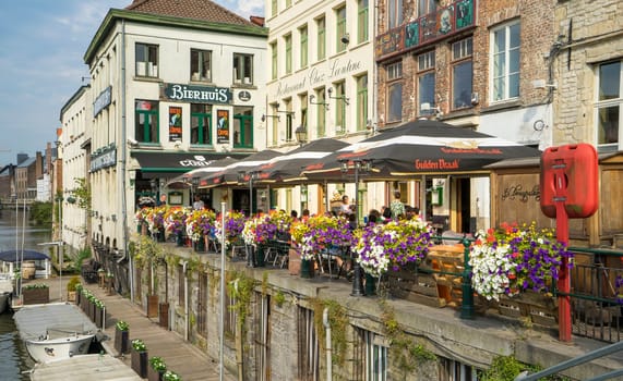 View of a nice corner with a terrace of a riverside bar in the Belgian city of Ghent. Place very frequented by tourists.