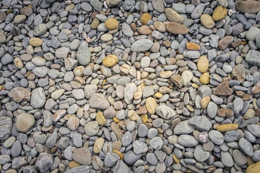 Set of rounded stones of different sizes and in gray tones on a beach.