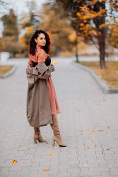 A woman walks outdoors in autumn, enjoys the autumn weather