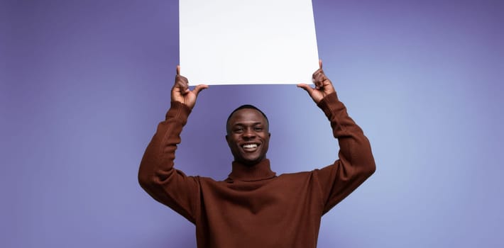 young american brunette man holding a square white screen for notes.