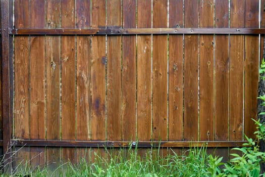 a barrier, railing, or other upright structure, typically of wood or wire, enclosing an area of ground