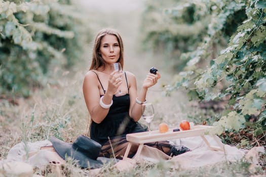 Picnic and wine tasting at sunset in the hills of Italy, Tuscany. Vineyards and open nature in the summer. Romantic dinner, fruit and wine.