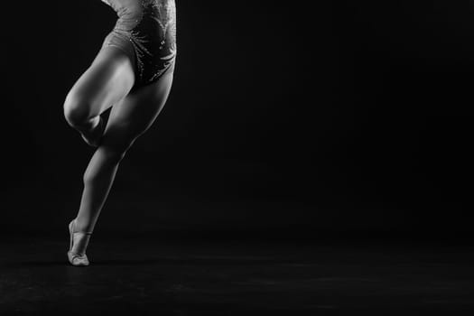 Full length teen girl smiling doing fitness exercises, isolated on a white and dark background