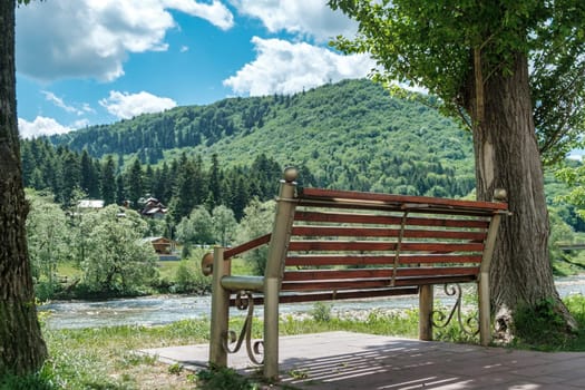 Bench in the mountains. Wooden bench in the mountain valley at the river, download photo