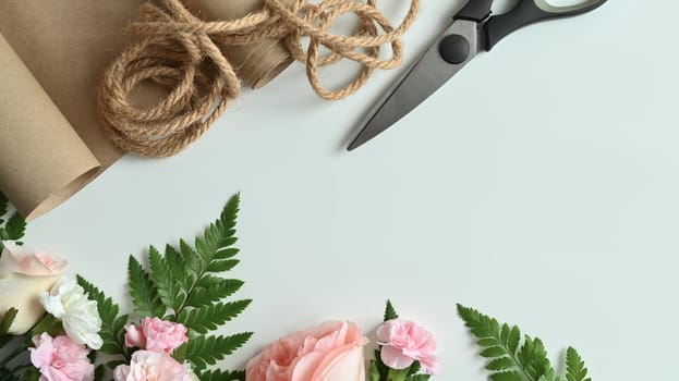 Florist equipment with fresh flowers on white background. Flat lay, top view with copy space.