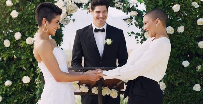 Love, holding hands and gay with lesbian couple at wedding for celebration, lgbtq and pride. Smile, spring and happiness with women at marriage event for partner commitment, romance and freedom.