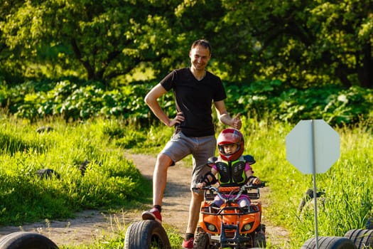 A child rides a quad bike through the mud. ATV rider rides.