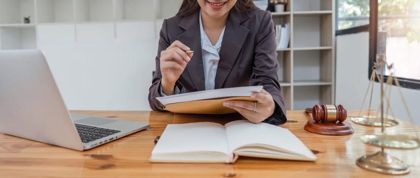 female lawyers working on laptop and contract documents at the law firms. Judge with scales of justice. Legal law, lawyer, advice and justice concept.