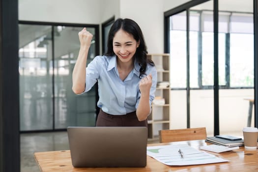 Overjoyed young businesswoman with laptop expressing excitement rejoicing in office, Excited business woman feel euphoric reading good news online.